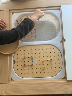 a child is playing with an electronic device made out of pegs and plastic parts