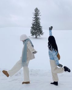 two people are walking in the snow with their feet up