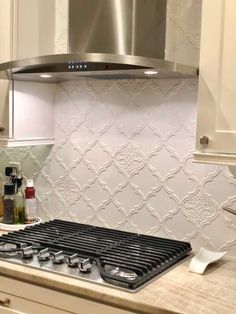 a stove top oven sitting inside of a kitchen next to a wall mounted range hood