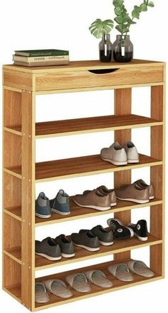 a wooden shoe rack with several pairs of shoes on it and a potted plant