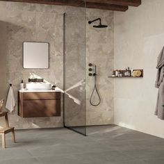 a bathroom with a walk in shower next to a sink and mirror on the wall