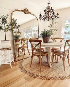 a dining room table with chairs and a large mirror on the wall next to it