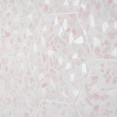 a pink and white wall with hexagonal tiles