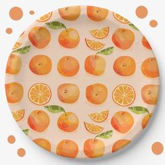 a plate with oranges on it and polka dots around the edges, all in different colors