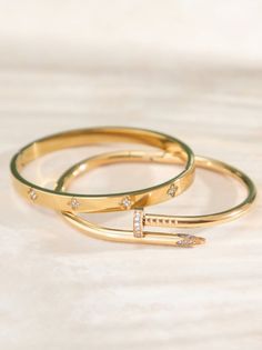 This unique wrapped nail bracelet adds an edgy touch to your look, while the clover bangle serves as an everyday staple. Bracelets Stacked, Nail Bangle, Gold Bracelets Stacked, Bday Wishlist, Nail Bracelet, Christmas Boots, Hand Bracelet, Stainless Steel Bangles, Gold Bracelets