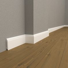 an empty room with wood floors and gray walls