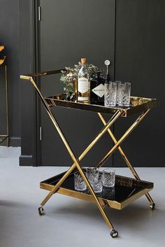 a gold bar cart with drinks on it and the words casino two tier drinks trolley