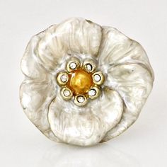 a gold and silver flower ring on a white surface