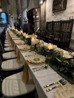 a long table is set with place settings and candles