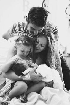 a man, woman and child are in bed with their arms around each other as they look at the camera