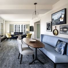 a living room filled with furniture and pictures on the wall next to a dining table