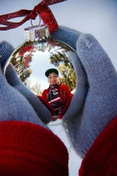 a person holding a christmas ornament in their hands