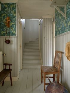 a wooden chair sitting on top of a hard wood floor next to a white wall