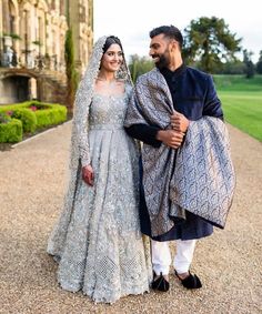 a bride and groom posing for a photo in front of a castle