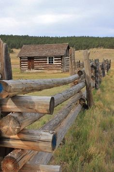 an old log fence in front of a cabin