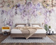 a bedroom with an artistic wallpaper and bedding in the foreground, there is a rug on the floor