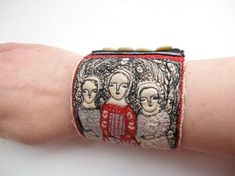 a woman's arm with a bracelet made out of fabric and beads on it