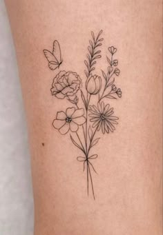 a small flower tattoo on the back of a woman's leg