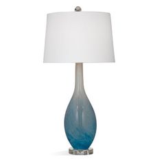 a blue glass table lamp with a white shade