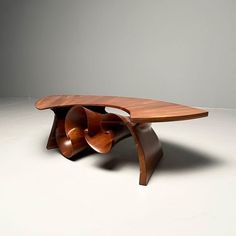 a wooden table sitting on top of a white floor next to a gray wall in an empty room