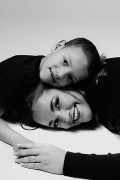 two people are laying on the floor posing for a black and white photo with their arms around each other