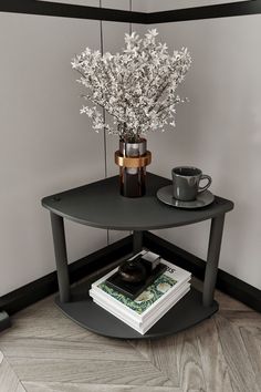 a vase with flowers on top of a table next to a cup and saucer