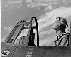 a black and white photo of a pilot in an airplane