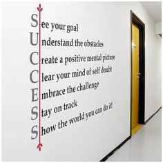 an office hallway with a wall decal that says see your goal, understand the obstacles