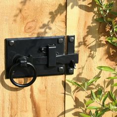 a black door handle on a wooden fence