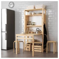 a kitchen area with a refrigerator, table and stools