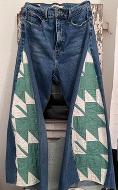 a pair of blue jeans with green and white designs on them