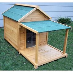 a wooden dog house with a green roof