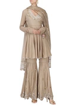 Featuring a beige short angrakha anarkali in cotton base with silver and gold gota patti and sequins hand embroidery and baby pink tassels. It is paired with matching gharara pants and an embroidered net dupatta.    FIT : Cut for relaxed fit.  COMPOSITION: Cotton, Net  CARE: Dryclean only. Angrakha Style Kurti, Angrakha Anarkali, Priyanka Singh, Gharara Pants, Gharara Designs, Sharara Designs, Beige Colour, Blouse Design Models, Indian Attire