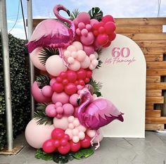 a flamingo balloon sculpture is displayed in front of a sign