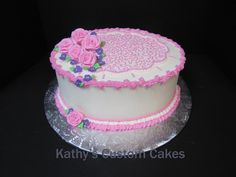 a white cake with pink frosting and flowers on top