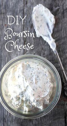 a glass bowl filled with sour cream cheese next to a spoon on top of a wooden table