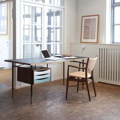 a desk with a laptop computer on top of it next to a radiator