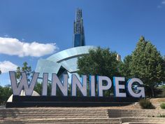 a large sign that says winnipeg in front of some stairs and trees