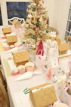 a decorated table with gingerbread houses and a christmas tree