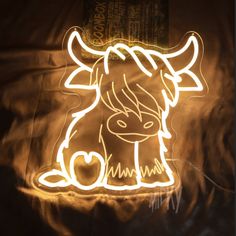 a light up cow sitting on top of a bed