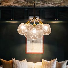 a living room filled with furniture and a chandelier hanging over the top of it