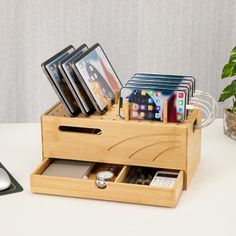 a wooden box with cell phones in it next to a computer mouse and keyboard on a table