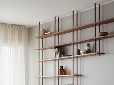 a living room filled with furniture and shelves next to a wall mounted shelf covered in books