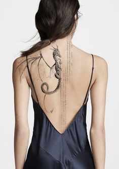 the back of a woman's body with tattoos on it