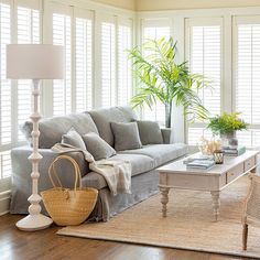 a living room filled with furniture and a large window covered in shuttered glass shades