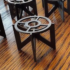 three metal tables sitting on top of a wooden floor