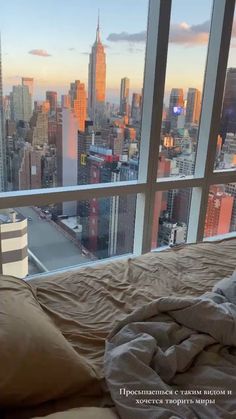 a bedroom with a large window overlooking the city