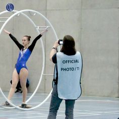 a woman standing in front of a hoop with her arms outstretched