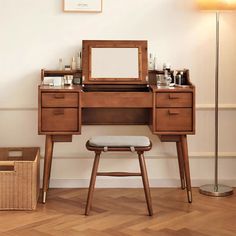 a wooden desk with a mirror, stool and other items on it next to a lamp