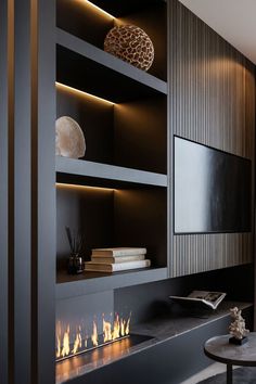 a modern fireplace with built - in shelves and lit fire inside the space between two walls